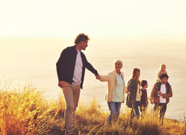 Multi-generational family walking together at sunset.
