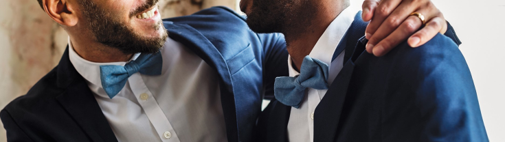 Two grooms smiling at each other
