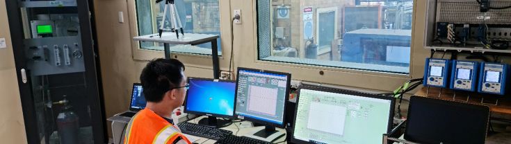 Image of man in high vis testing behind double glazed glass