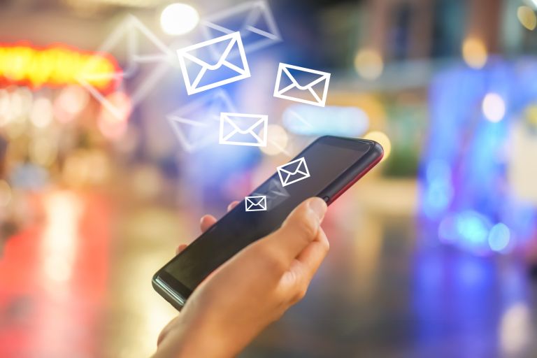 Woman hand using smartphone to send and receive email.