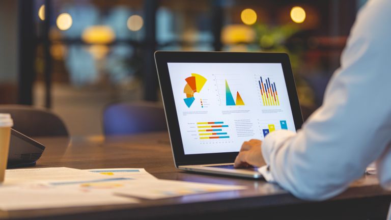 Close up of businessman using a laptop with graphs and charts on a laptop computer.