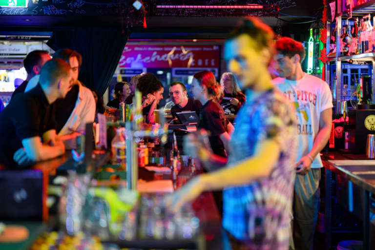 A brightly coloured bar with people waiting to purchase drinks